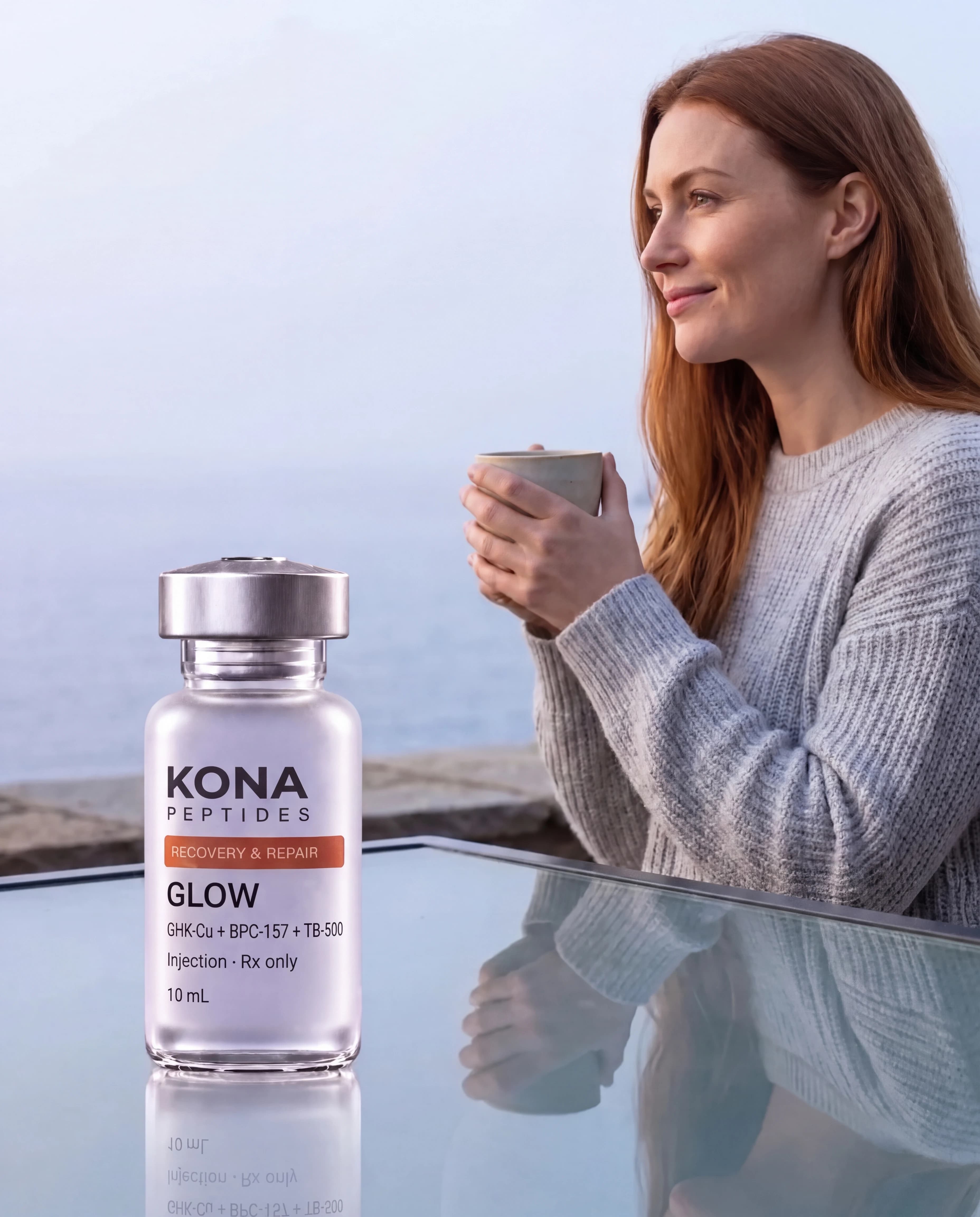 A GLOW vial in front of a woman holding a mug by the sea