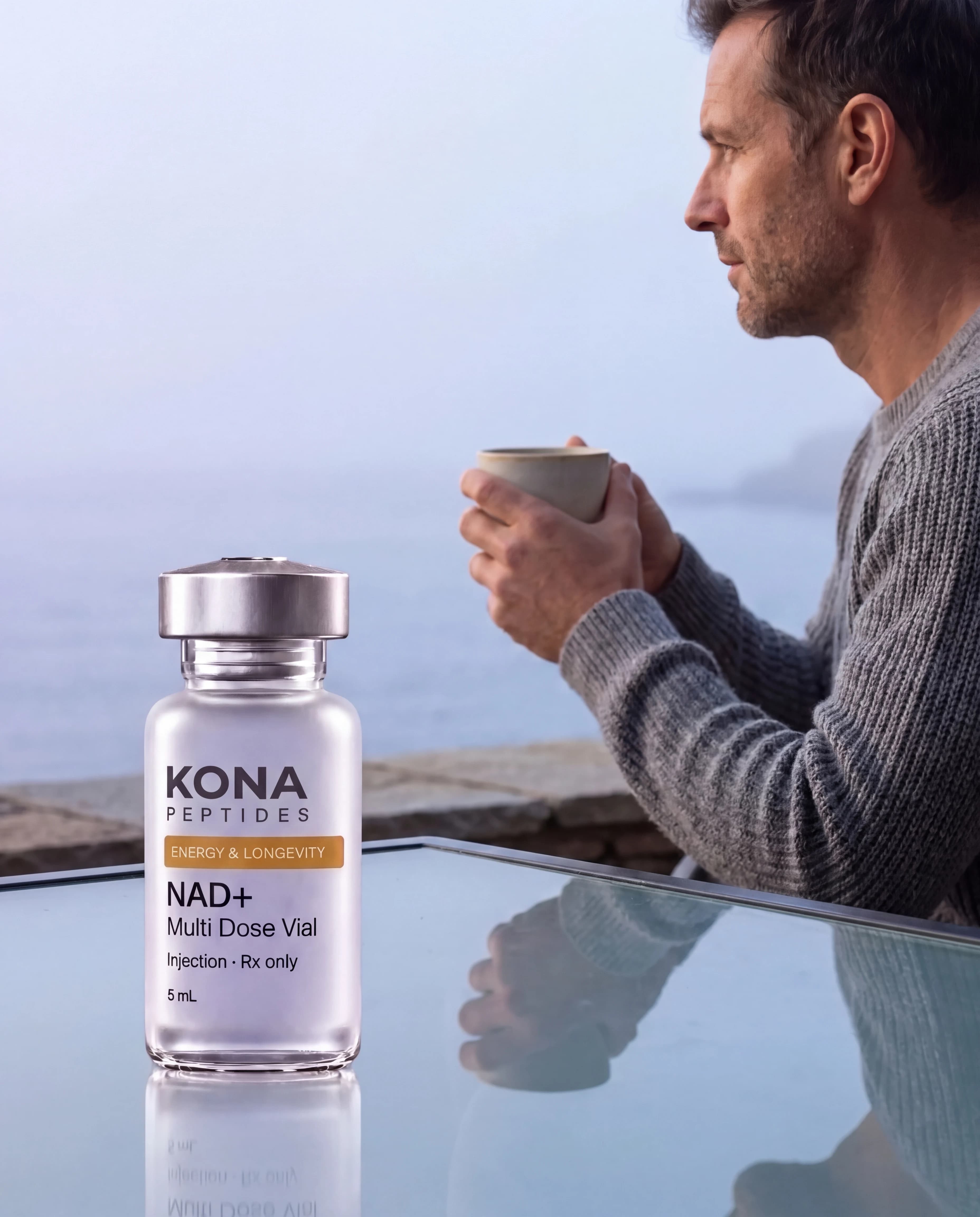 An NAD+ vial in front of a man with a coffee looking out to sea