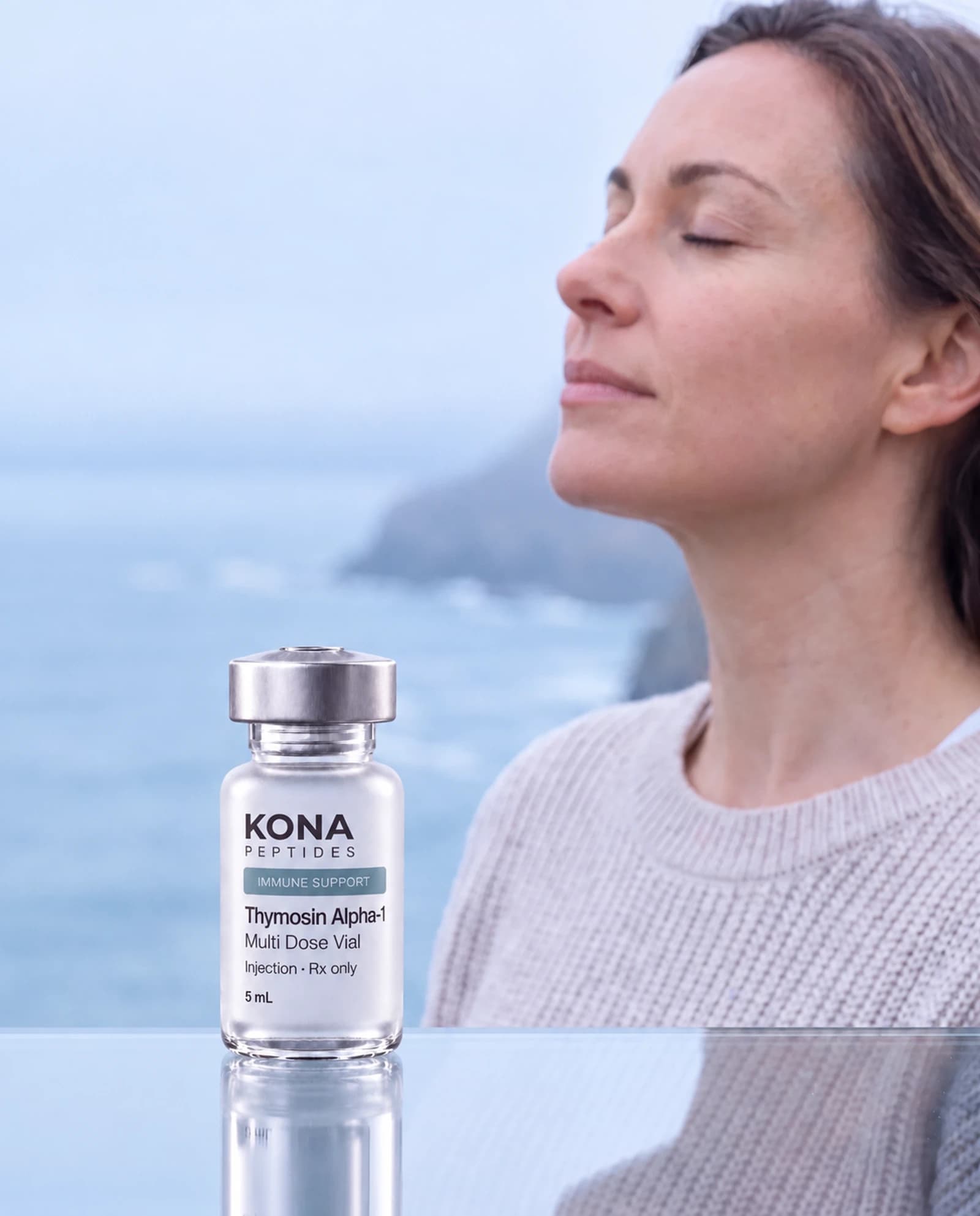 A Thymosin Alpha-1 vial beside a woman breathing sea air